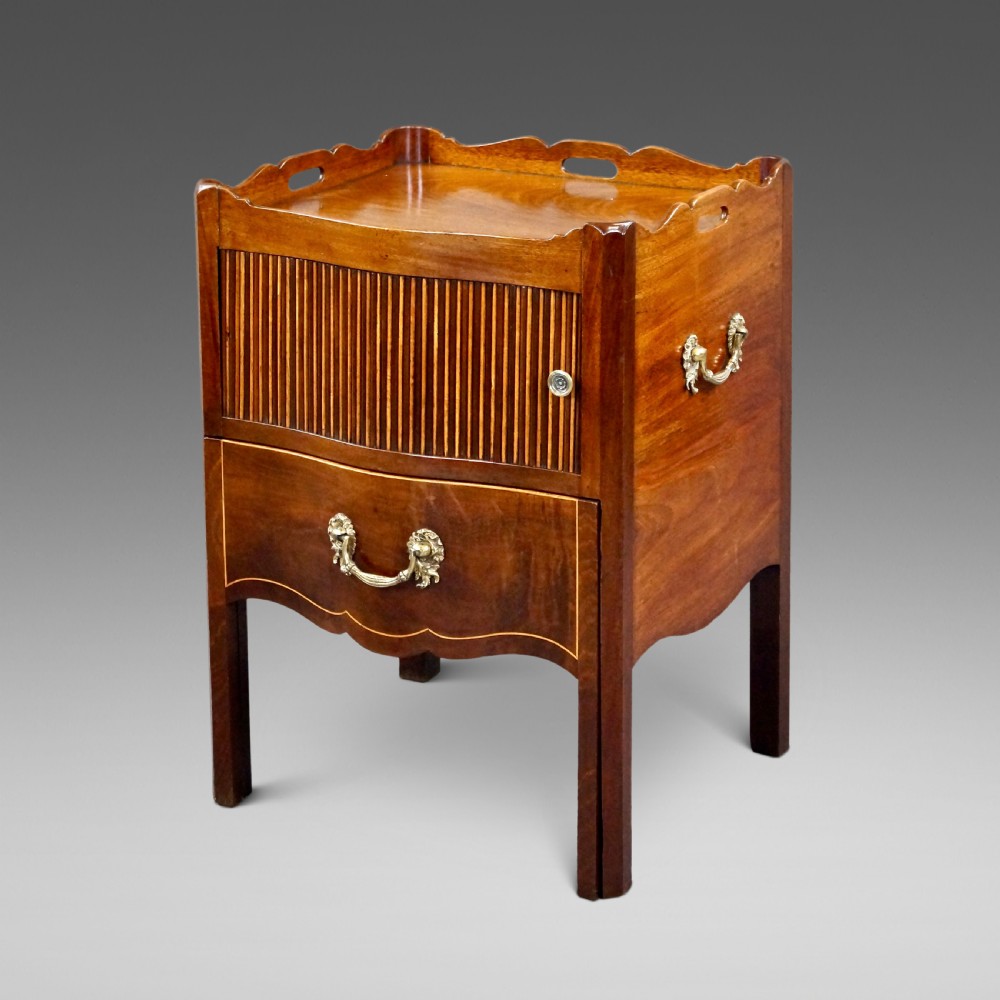 A Georgian mahogany tray-top commode featuring a galleried rim with cut-out handles, a slatted tambour door, and a lower serpentine drawer with brass pulls.