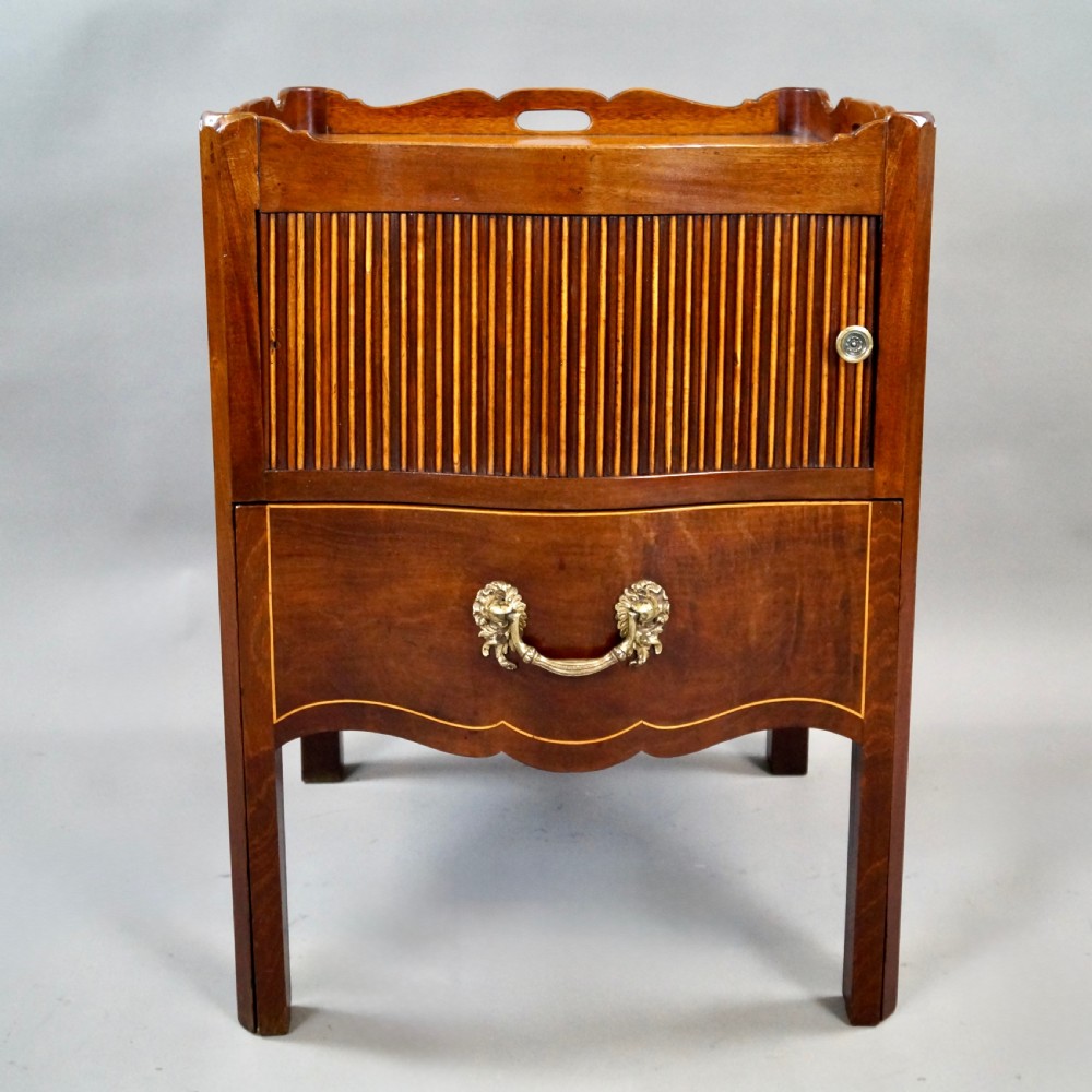 A Georgian mahogany tray-top commode featuring a galleried rim with cut-out handles, a slatted tambour door, and a lower serpentine drawer with brass pulls. View II