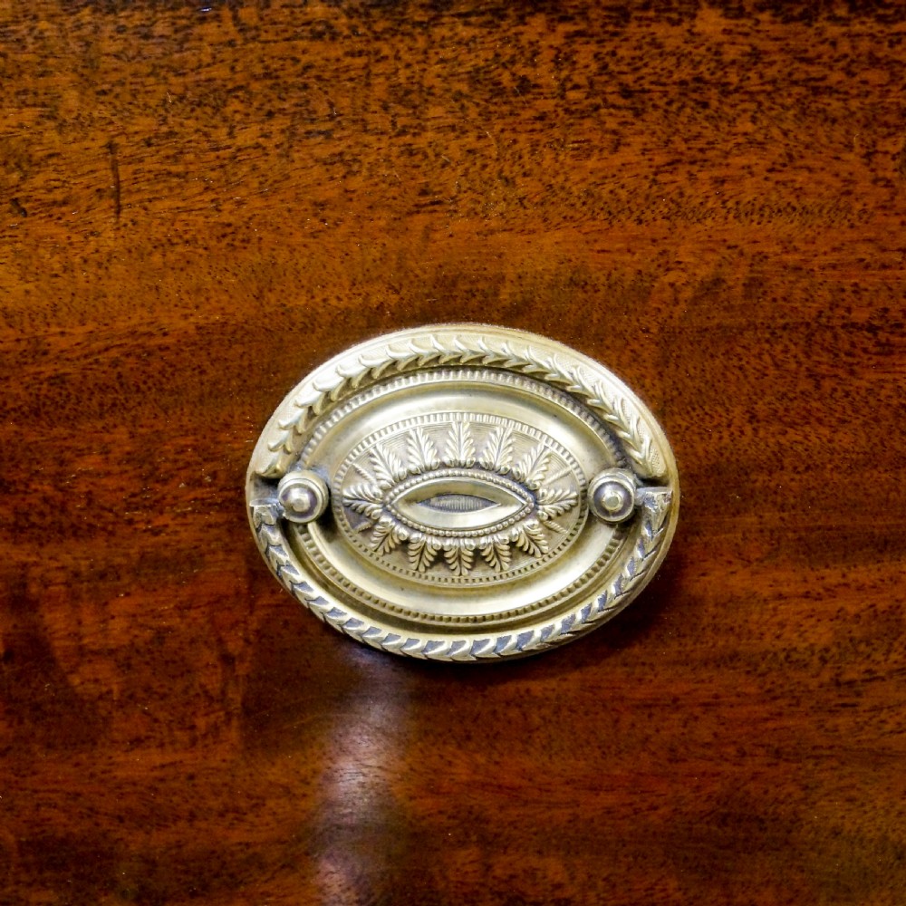 A Georgian mahogany bow-fronted tallboy featuring two sections with multiple graduated drawers, brass oval handles, an inlaid top frieze, and splayed bracket feet. View III