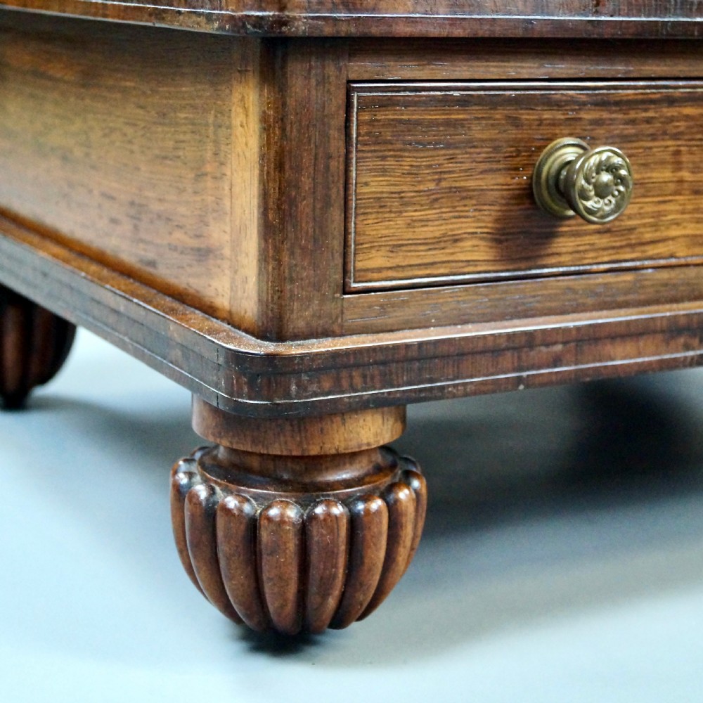 A pair of antique rosewood tiered whatnots featuring adjustable sloped reading tops, turned spindle supports, single drawers at the base, and lobed bun feet. View IV