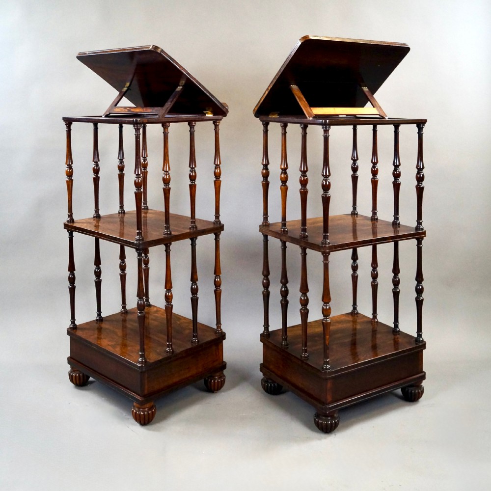 A pair of antique rosewood tiered whatnots featuring adjustable sloped reading tops, turned spindle supports, single drawers at the base, and lobed bun feet. View V