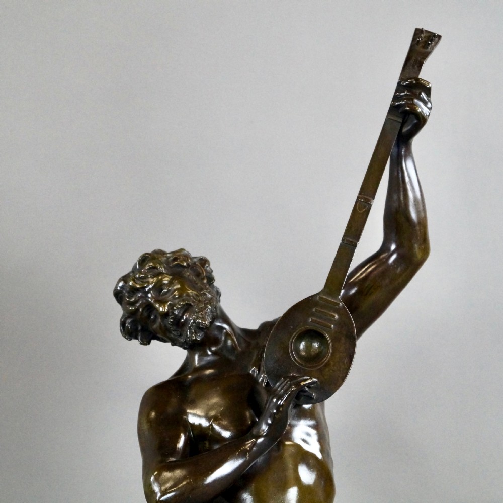 A pair of 19th-century dark bronze sculptures depicting a female musician with a tambourine and a male figure playing a lute, both set on circular red marble bases. View V