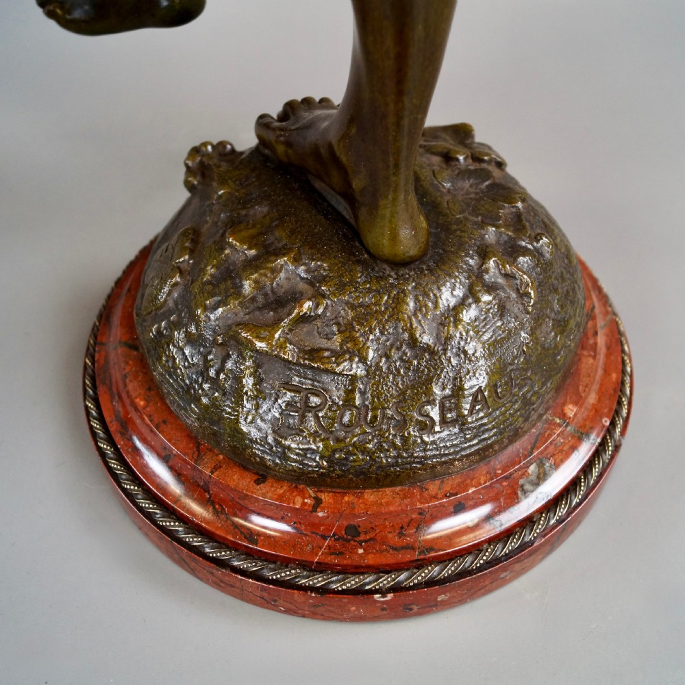 A pair of 19th-century dark bronze sculptures depicting a female musician with a tambourine and a male figure playing a lute, both set on circular red marble bases. View VII