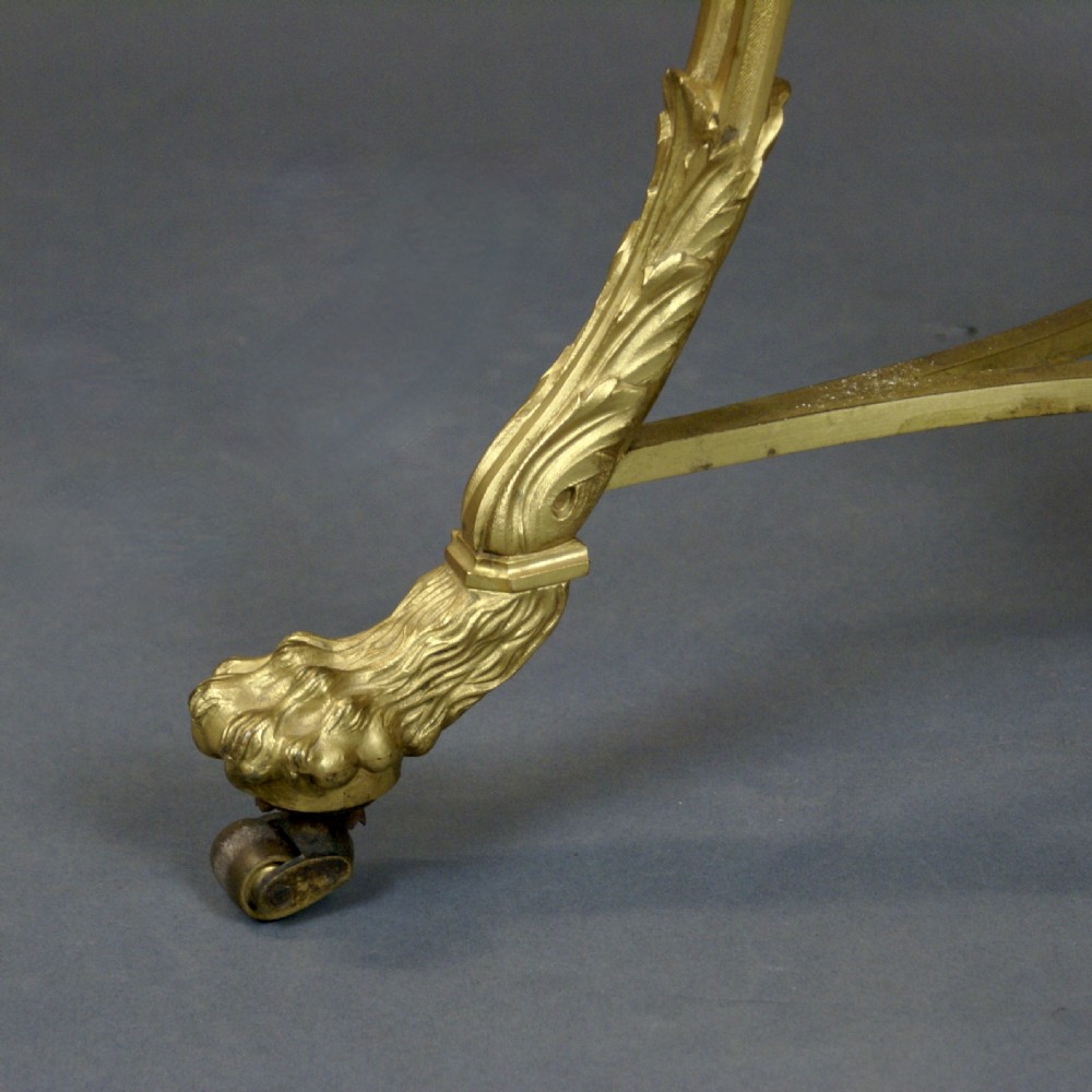 A circular French ormolu gueridon table featuring grey marble tops, a pierced gilt gallery, lion mask mounts with ring handles, and tripod legs terminating in paw feet. View IV