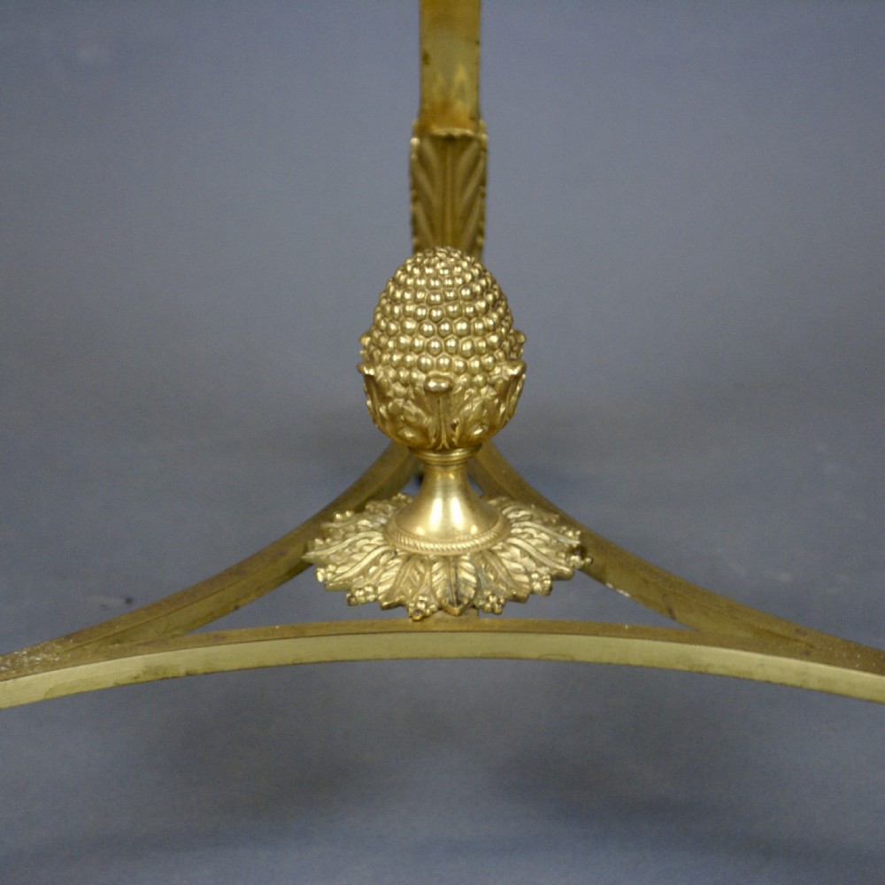 A circular French ormolu gueridon table featuring grey marble tops, a pierced gilt gallery, lion mask mounts with ring handles, and tripod legs terminating in paw feet. View V