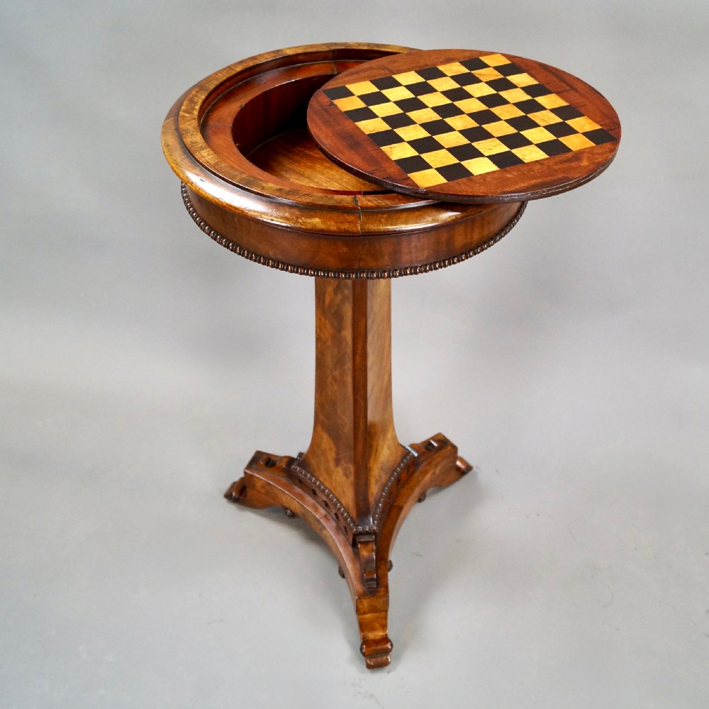 A William IV mahogany circular chess table with an inlaid board, tapered central stem, and triform base on scroll feet. View III