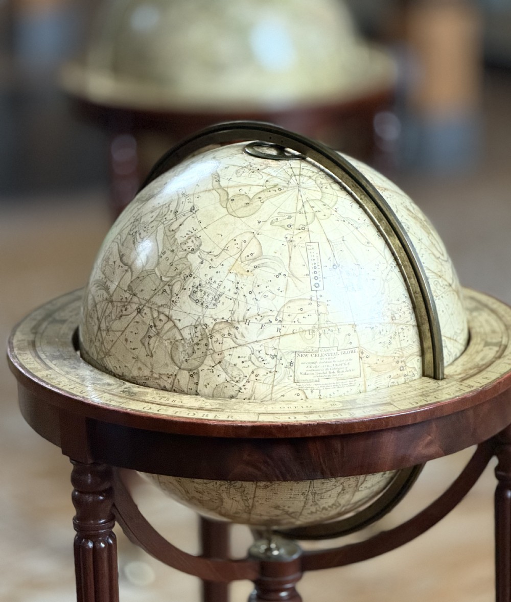 A pair of floor-standing antique globes on turned mahogany reeded legs with brass meridian rings and integral compasses set into the lower stretchers. View IV