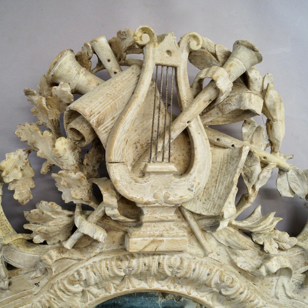 An eighteenth-century carved Italian wall mirror with a lyre crest motif, floral details, distressed off-white finish, and a lion mask base. View II