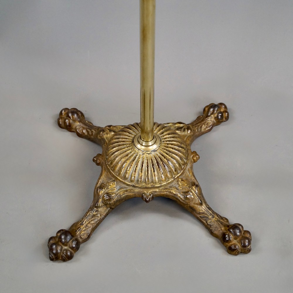 A late 19th-century Victorian reading stand with an adjustable brass stem, articulated arm holding a tilted mahogany book rest, a small central round mahogany shelf, and an ornate cast base. View II