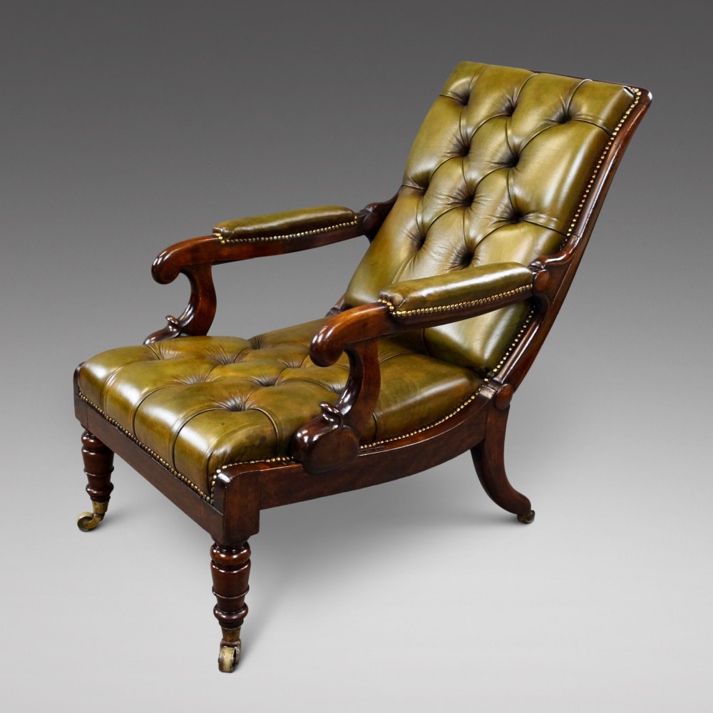 A William IV reclining armchair upholstered in deep-buttoned olive green leather with a mahogany frame, scroll arms, and brass castors.