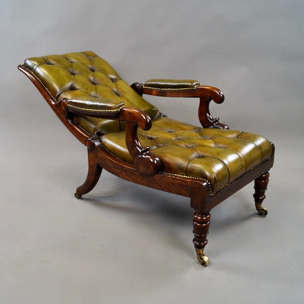 A William IV reclining armchair upholstered in deep-buttoned olive green leather with a mahogany frame, scroll arms, and brass castors. View II