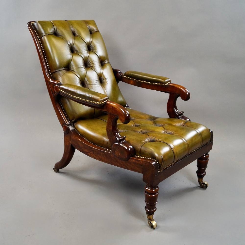 A William IV reclining armchair upholstered in deep-buttoned olive green leather with a mahogany frame, scroll arms, and brass castors. View III