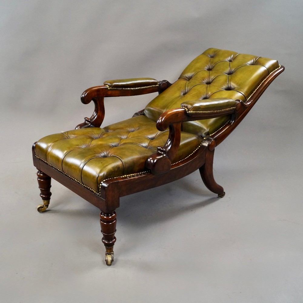 A William IV reclining armchair upholstered in deep-buttoned olive green leather with a mahogany frame, scroll arms, and brass castors. View IV