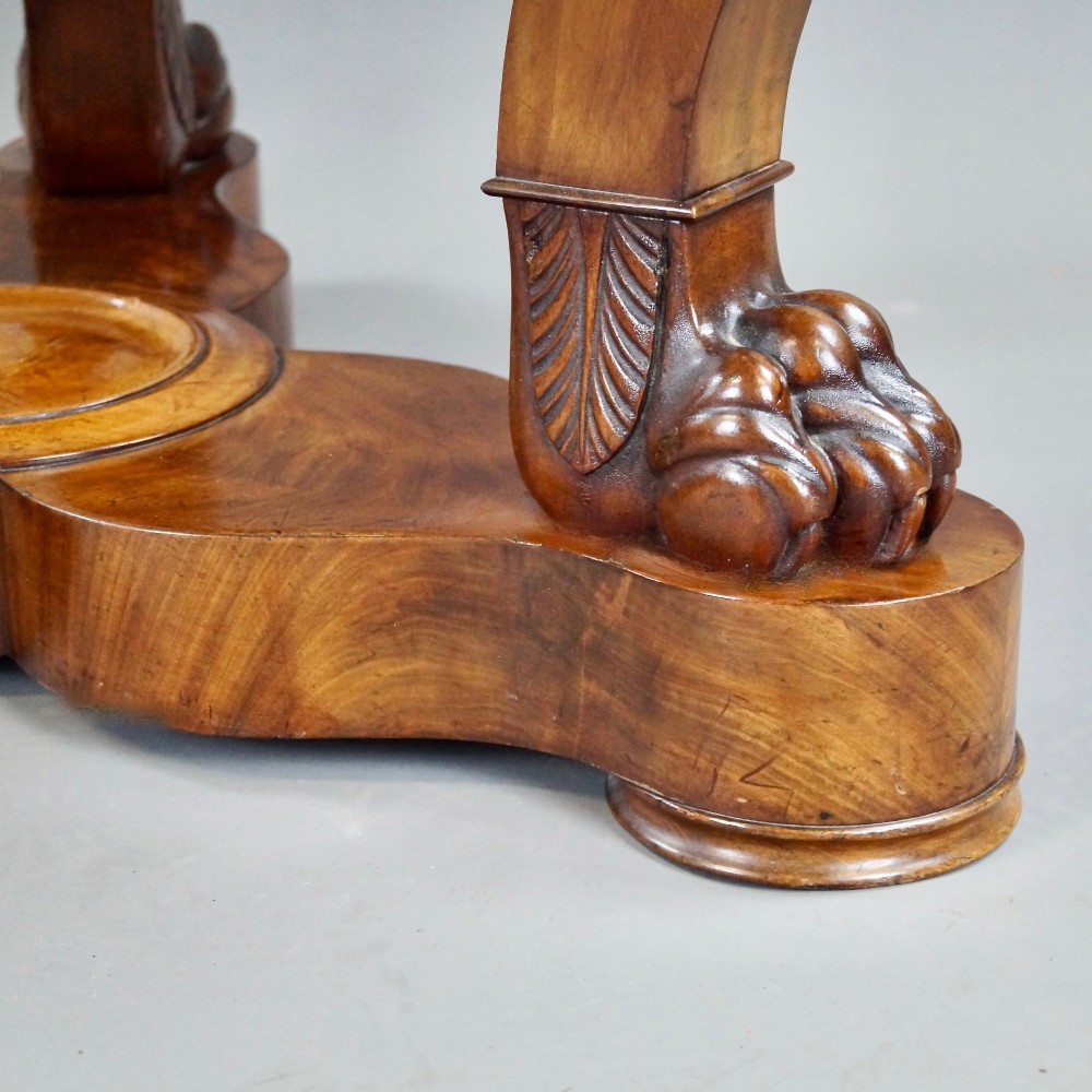 A circular French Empire mahogany gueridon table featuring a grey marble top, gilt bronze mounts, curved tripod legs, and carved lion paw feet on a plinth base. View IV