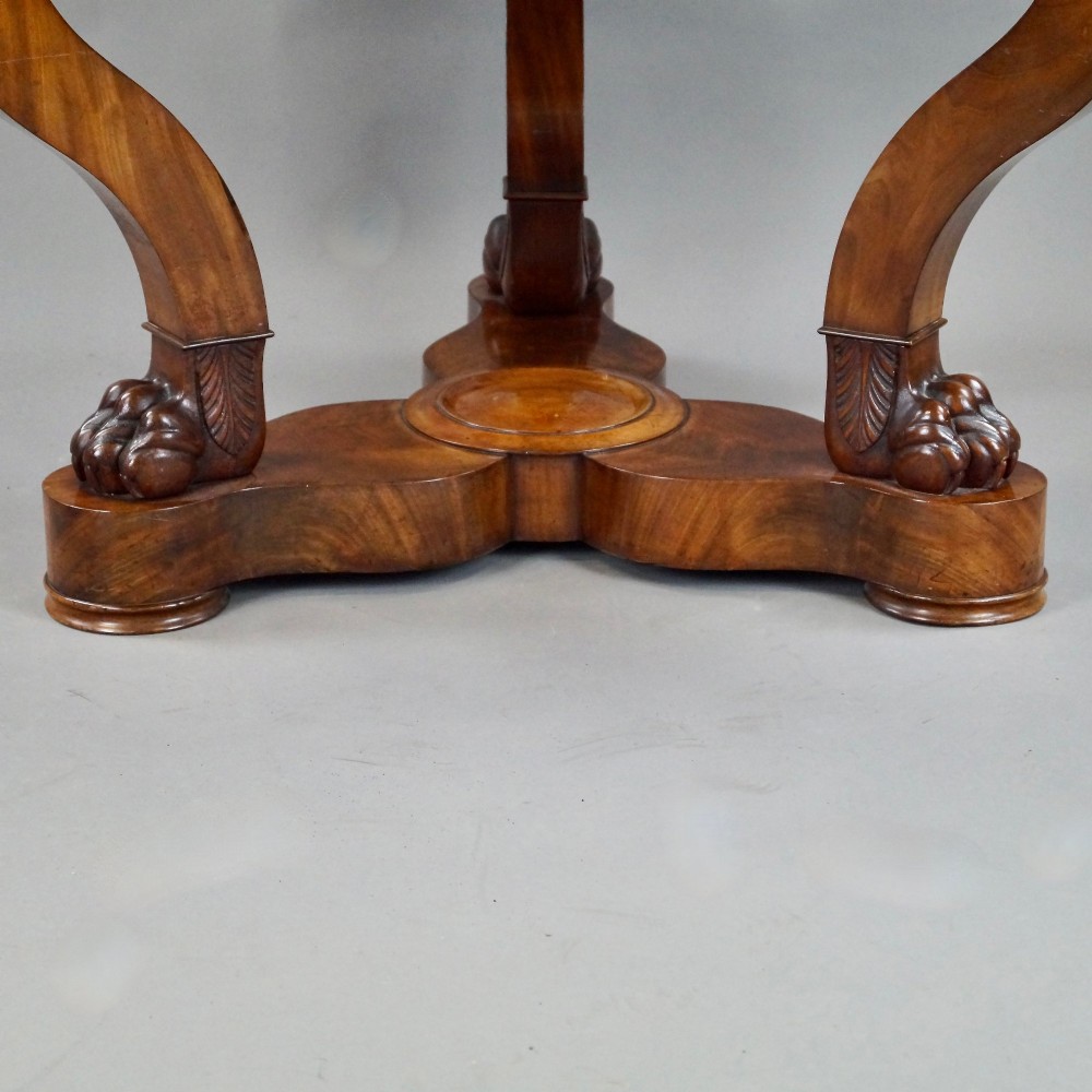 A circular French Empire mahogany gueridon table featuring a grey marble top, gilt bronze mounts, curved tripod legs, and carved lion paw feet on a plinth base. View VI