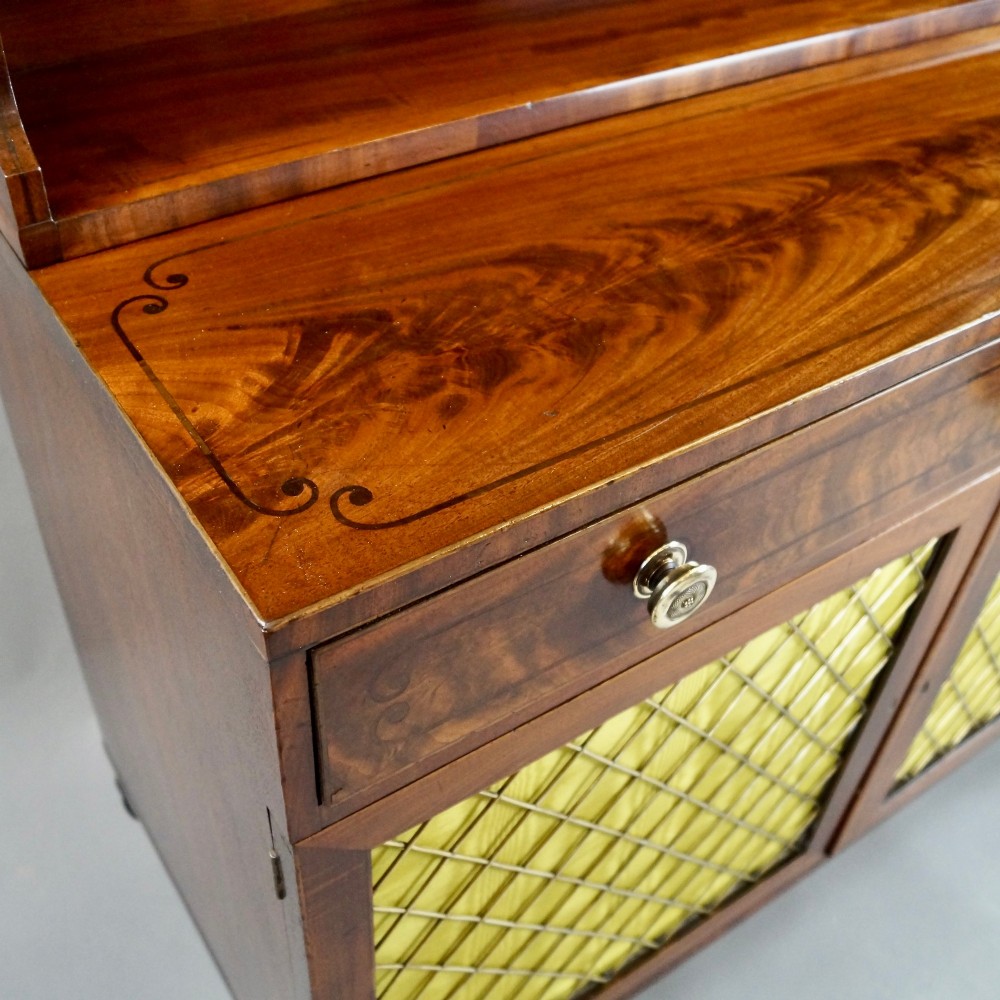 A Regency mahogany waterfall bookcase featuring graduated open shelves above a single drawer and lower cupboard doors with brass wire grilles. View III