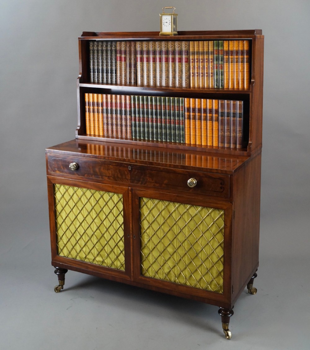 A Regency mahogany waterfall bookcase featuring graduated open shelves above a single drawer and lower cupboard doors with brass wire grilles. View IV