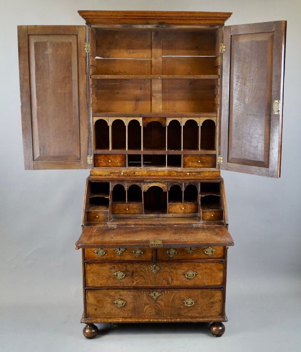 A William and Mary burr elm bureau bookcase featuring a twin-panel upper cabinet over a slant-front desk and four lower drawers on turned bun feet. View IV