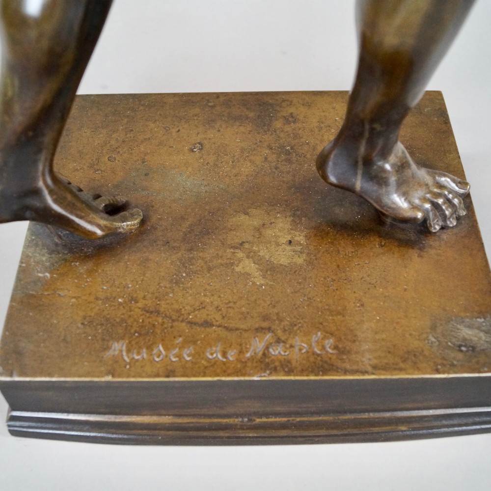 A late nineteenth-century dark brown patinated bronze sculpture depicting a dancing faun on a square plinth base. View VI