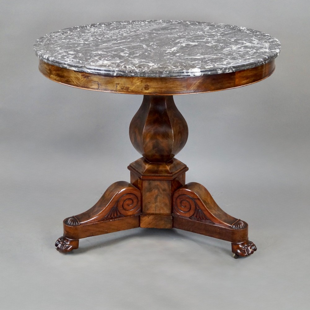 A 19th-century French circular gueridon centre table featuring a flame mahogany veneer pedestal base and a grey veined marble top resting on a triform plinth. View IV