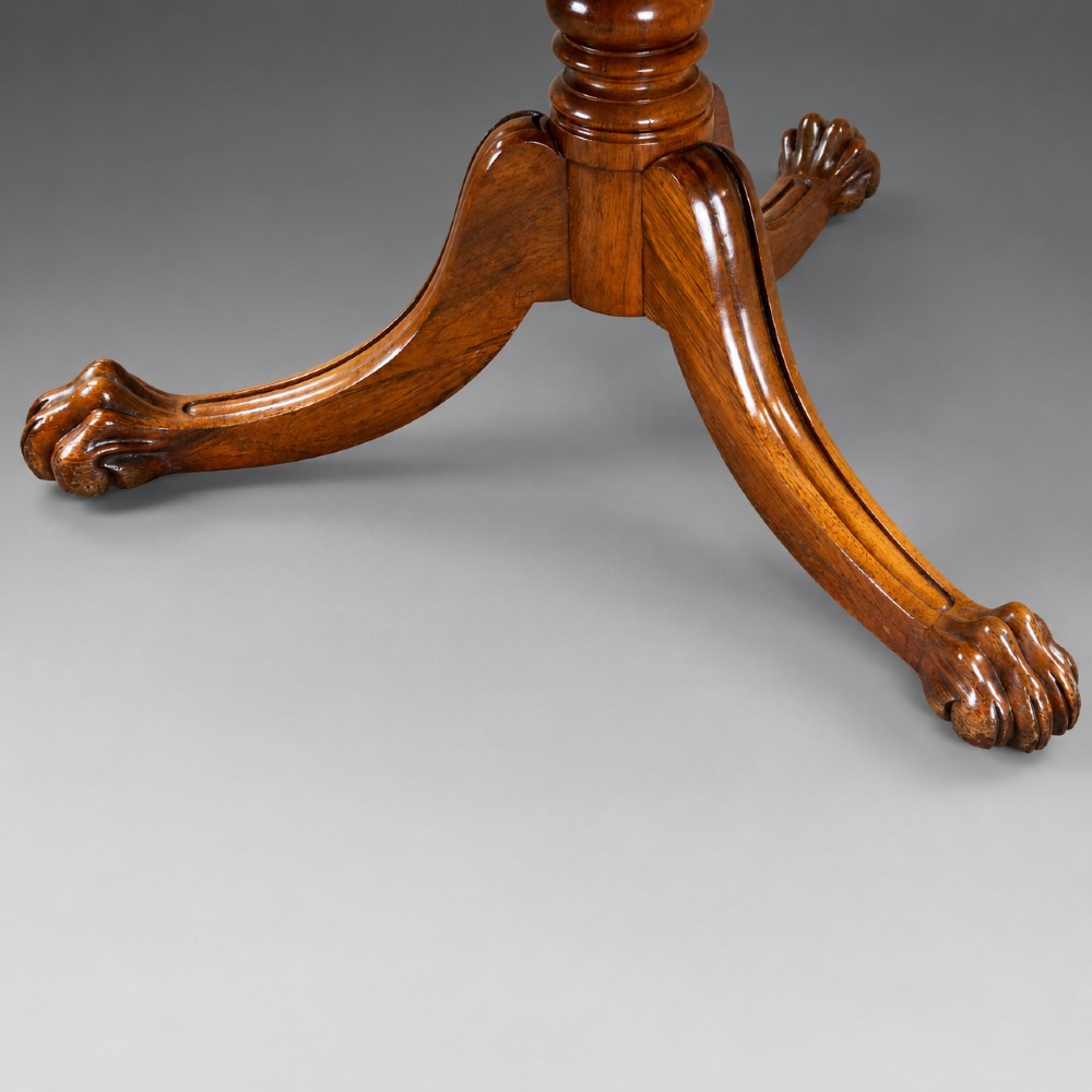 A circular Regency rosewood drum table featuring a black leather insert, perimeter drawers with turned knobs, and a central pedestal with splayed carved legs. View IV