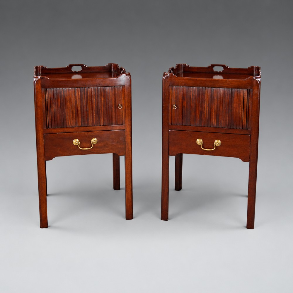 A pair of Georgian style mahogany bedside cupboards featuring top gallery trays with cut-out handles, slatted tambour doors, single lower drawers with brass handles, and square legs. View II