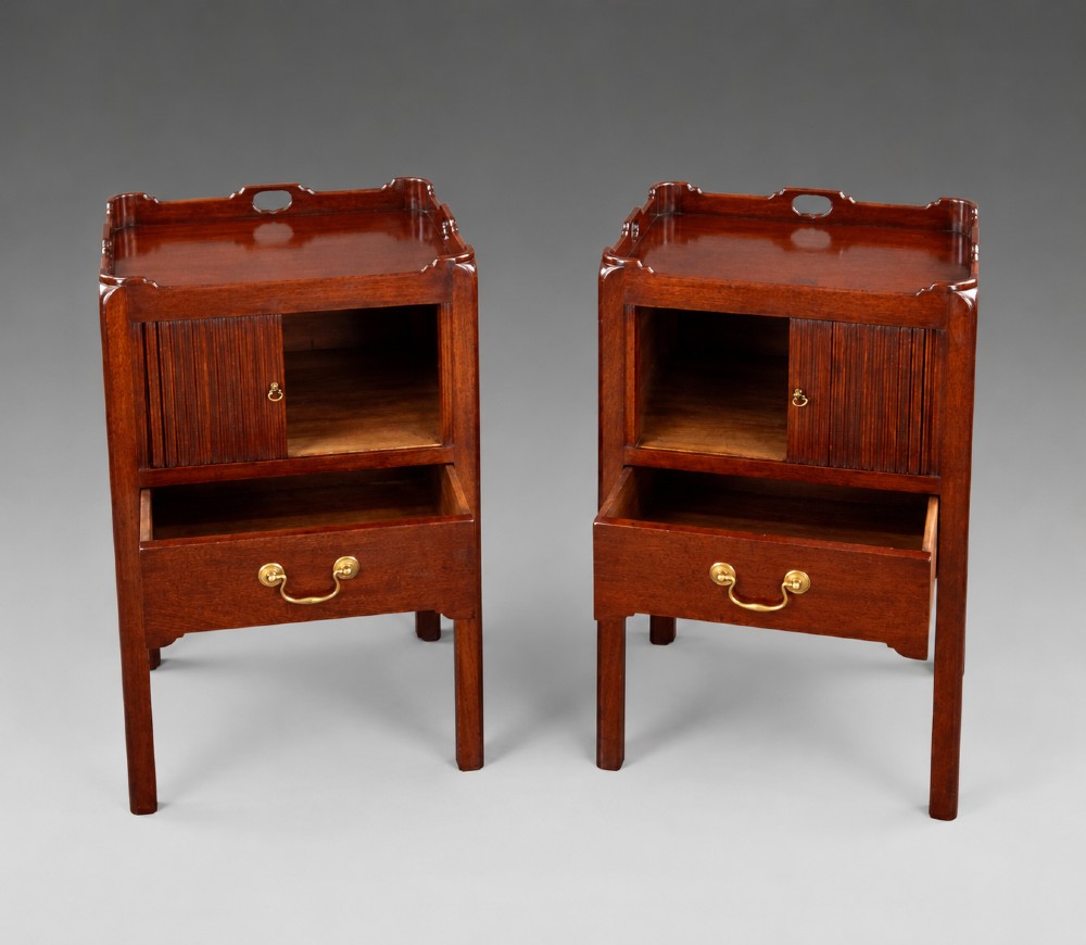 A pair of Georgian style mahogany bedside cupboards featuring top gallery trays with cut-out handles, slatted tambour doors, single lower drawers with brass handles, and square legs. View IV