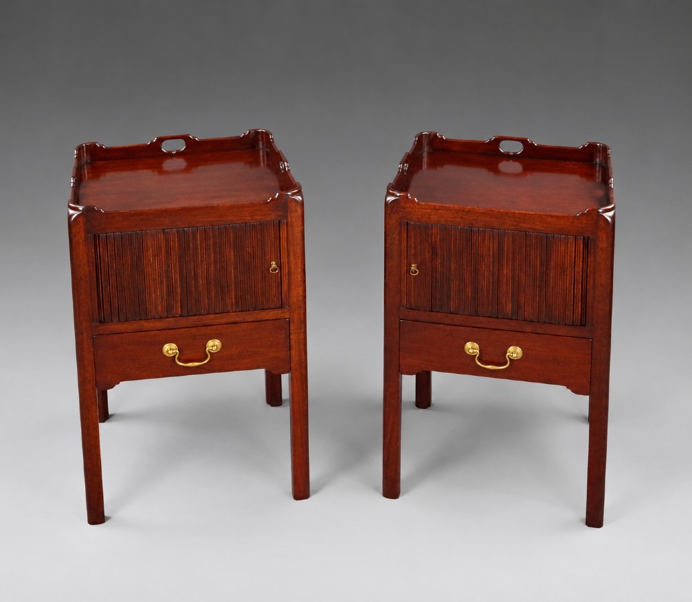 A pair of Georgian style mahogany bedside cupboards featuring top gallery trays with cut-out handles, slatted tambour doors, single lower drawers with brass handles, and square legs. View V