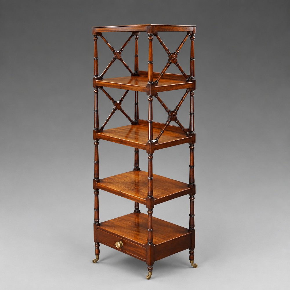 A tall George III mahogany four-tier whatnot featuring X-frame lattice sides on upper tiers, turned upright supports, a single drawer with a brass knob, and brass castors. View II