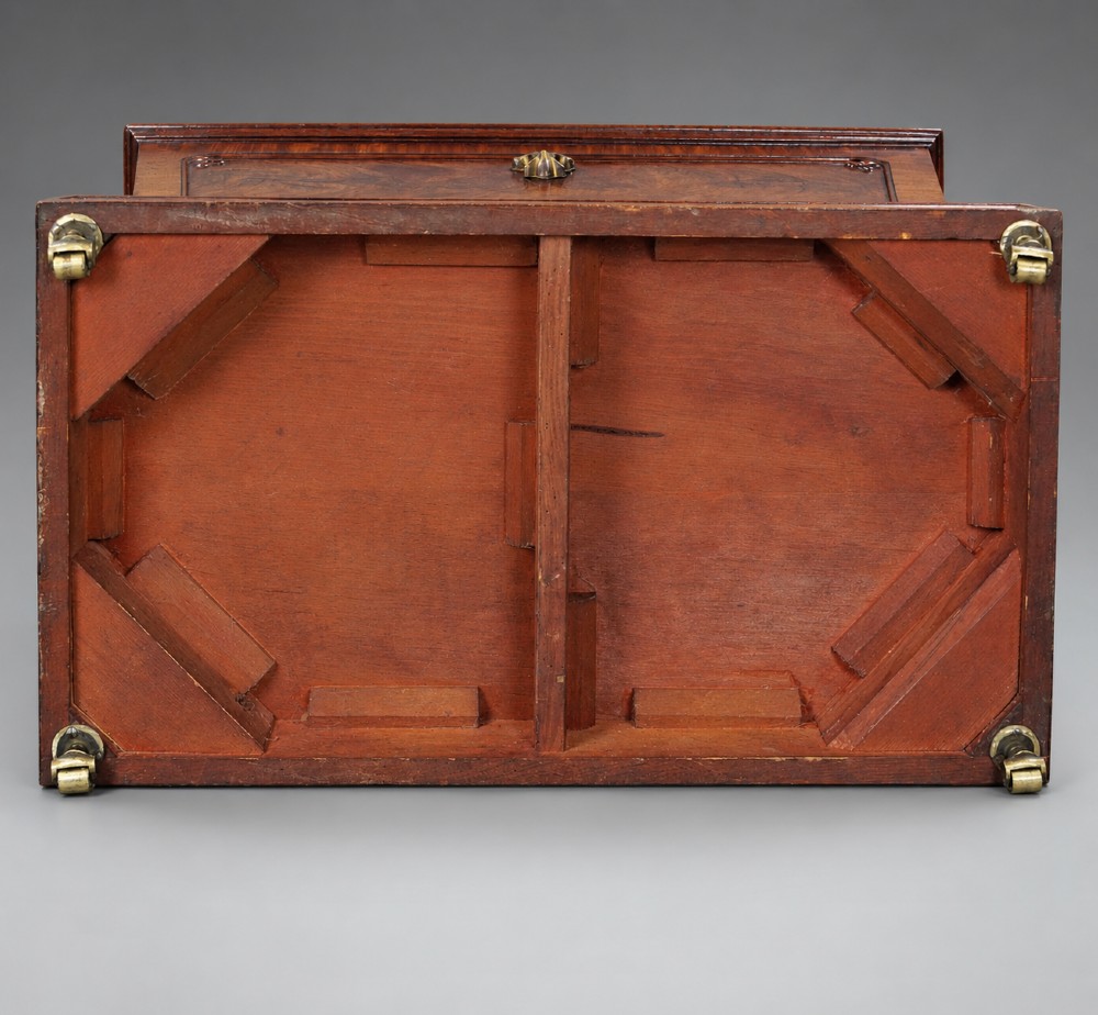 A Regency flame mahogany tapered wine cooler with a central brass escutcheon, supported by turned spherical feet and a rectangular plinth base. View IV