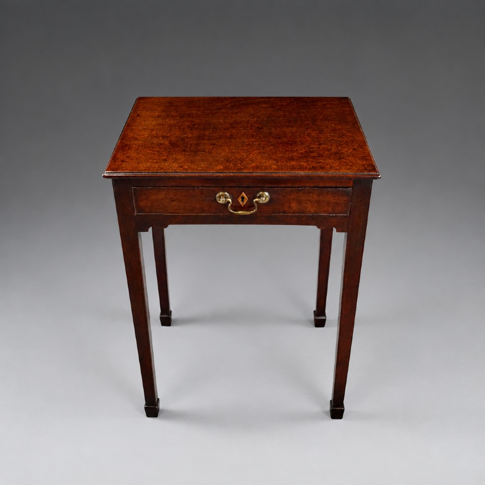 A George III mahogany side table featuring a single drawer with a central brass handle, supported by four tapered square legs. View III