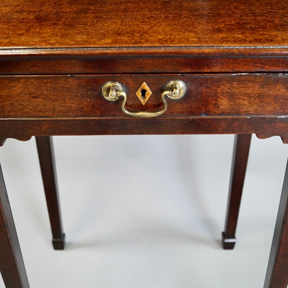 A George III mahogany side table featuring a single drawer with a central brass handle, supported by four tapered square legs. View IV