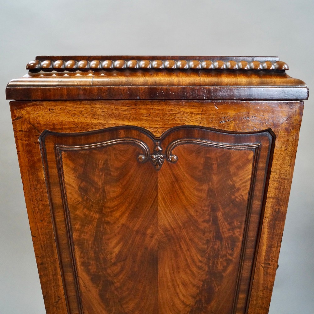 A pair of antique Regency flame mahogany pedestals featuring carved beadwork, framed door panels, and prominent carved lion paw feet. View IV