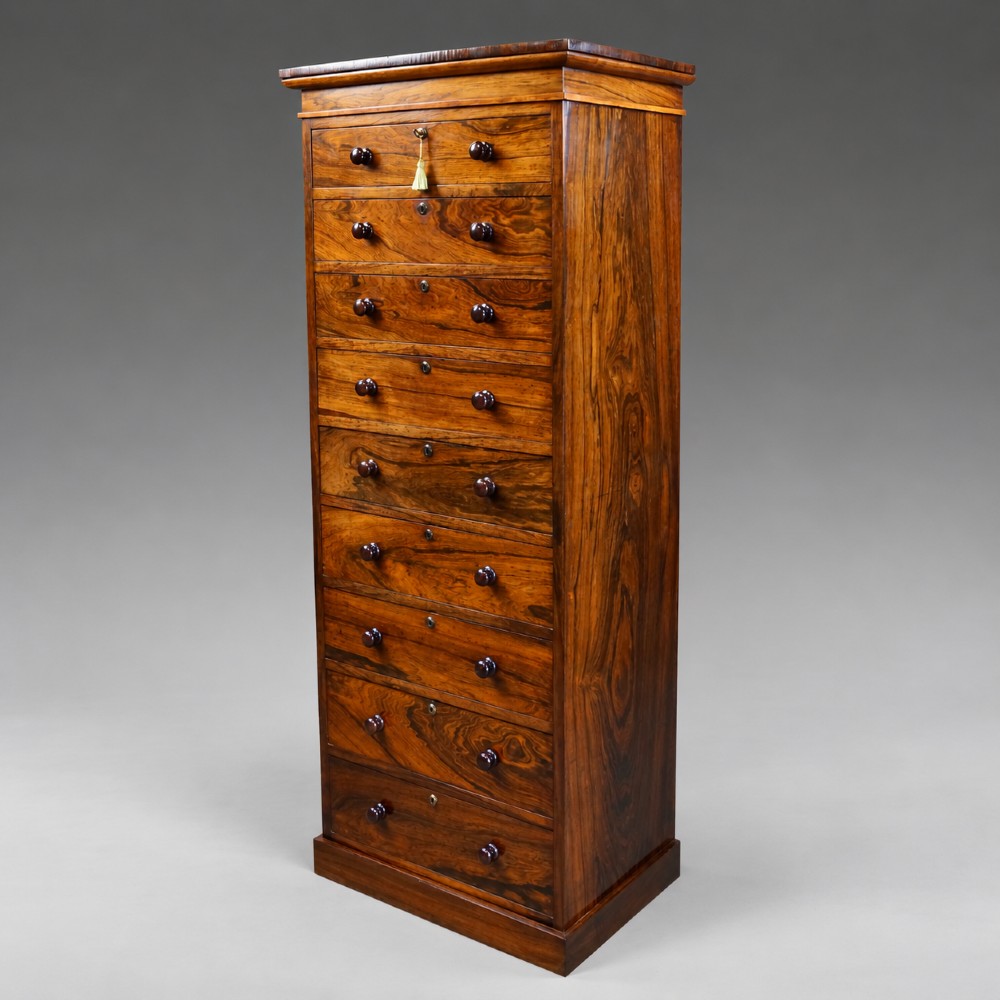 A tall, narrow antique rosewood chest of nine graduated drawers featuring turned wooden knobs and highly figured timber grain. View II