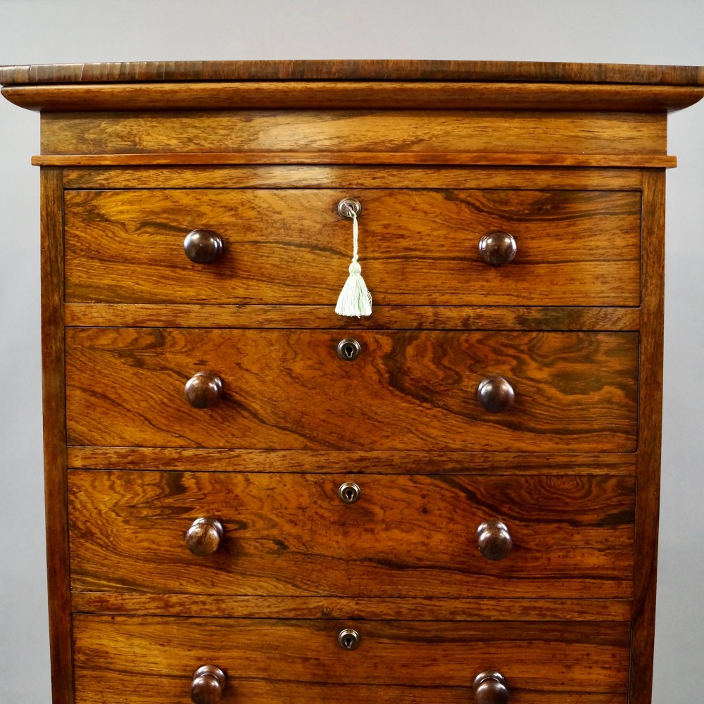 A tall, narrow antique rosewood chest of nine graduated drawers featuring turned wooden knobs and highly figured timber grain. View III