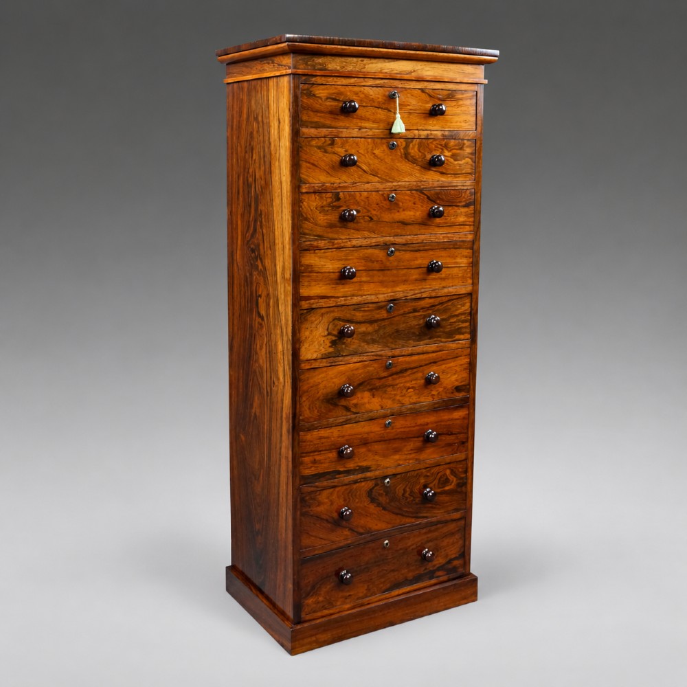 A tall, narrow antique rosewood chest of nine graduated drawers featuring turned wooden knobs and highly figured timber grain. View V