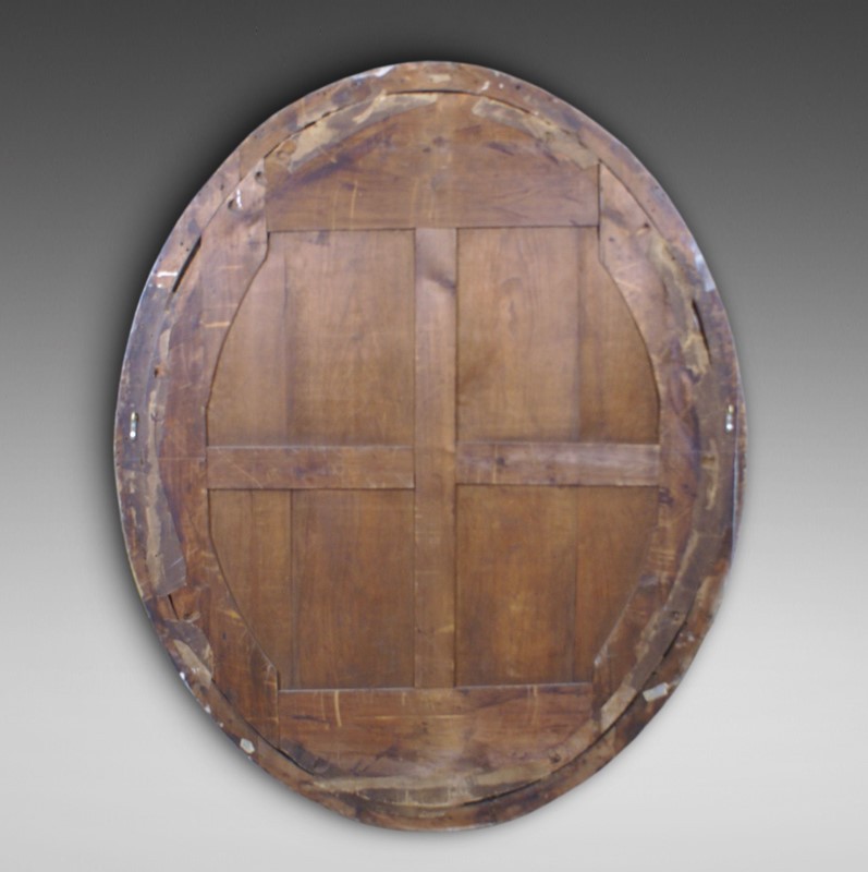 A large 19th-century oval wall mirror featuring a gilded wood frame with subtle beaded moulding. View II