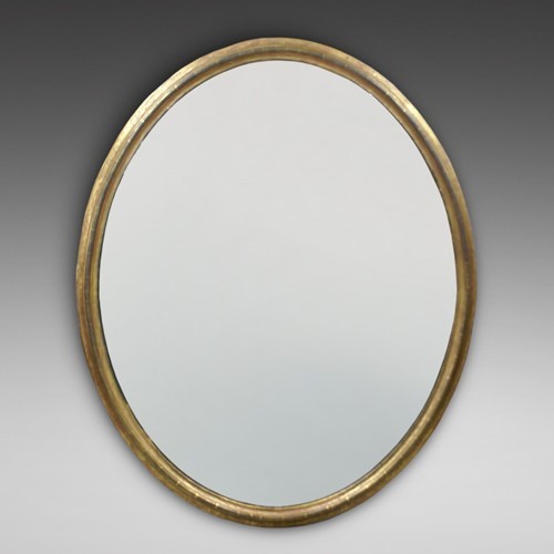 A large 19th-century oval wall mirror featuring a gilded wood frame with subtle beaded moulding. View III