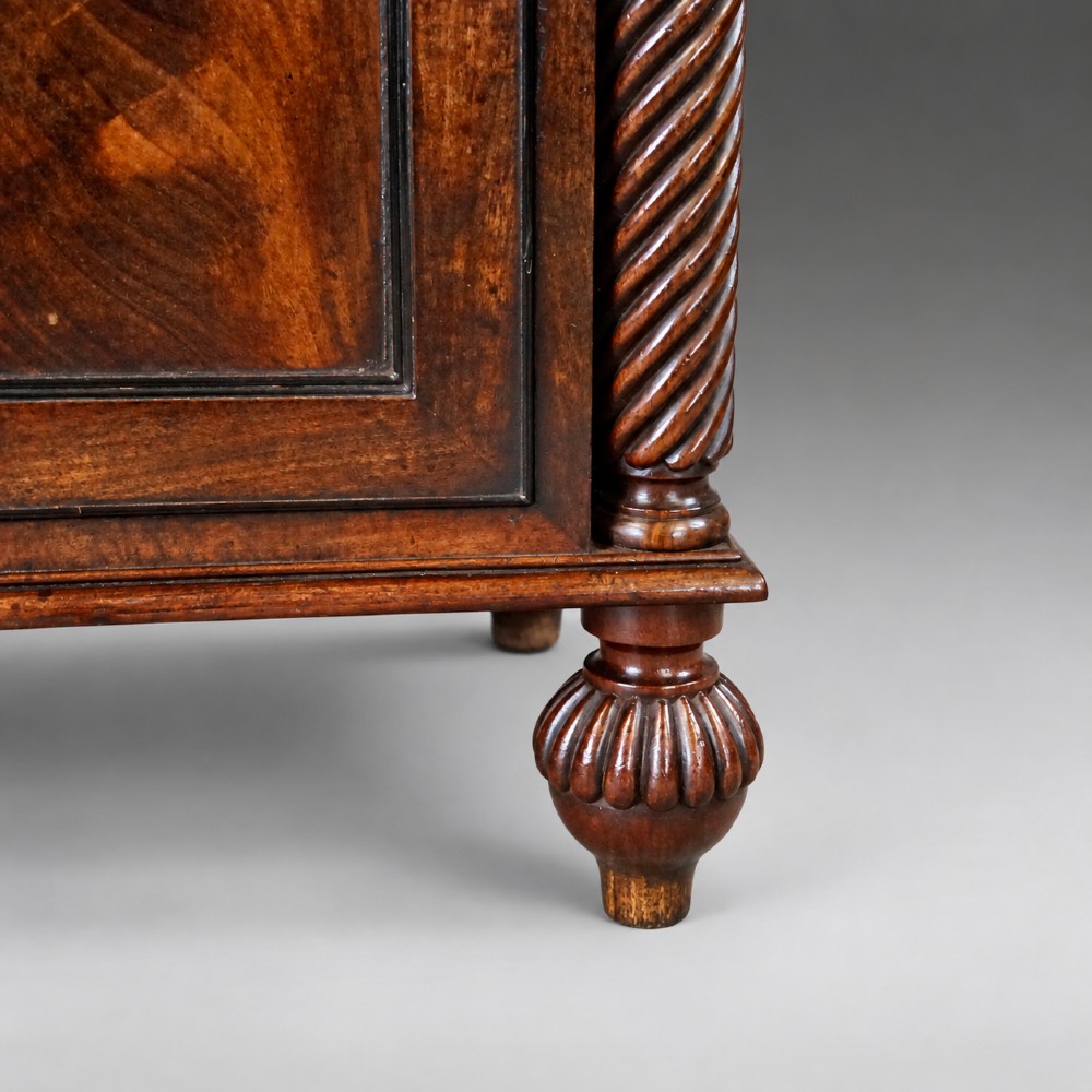 A pair of antique mahogany bedside cupboards with flame mahogany panel doors flanked by spiral-twist columns and supported by lobed bun feet. View III