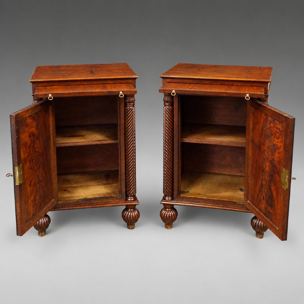 A pair of antique mahogany bedside cupboards with flame mahogany panel doors flanked by spiral-twist columns and supported by lobed bun feet. View IV