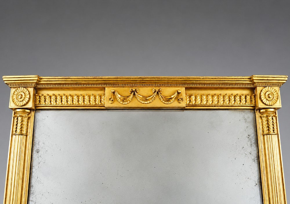A tall rectangular George III giltwood pier mirror with fluted pilasters, a central drapery swag frieze, and a two-section mirror plate. View III
