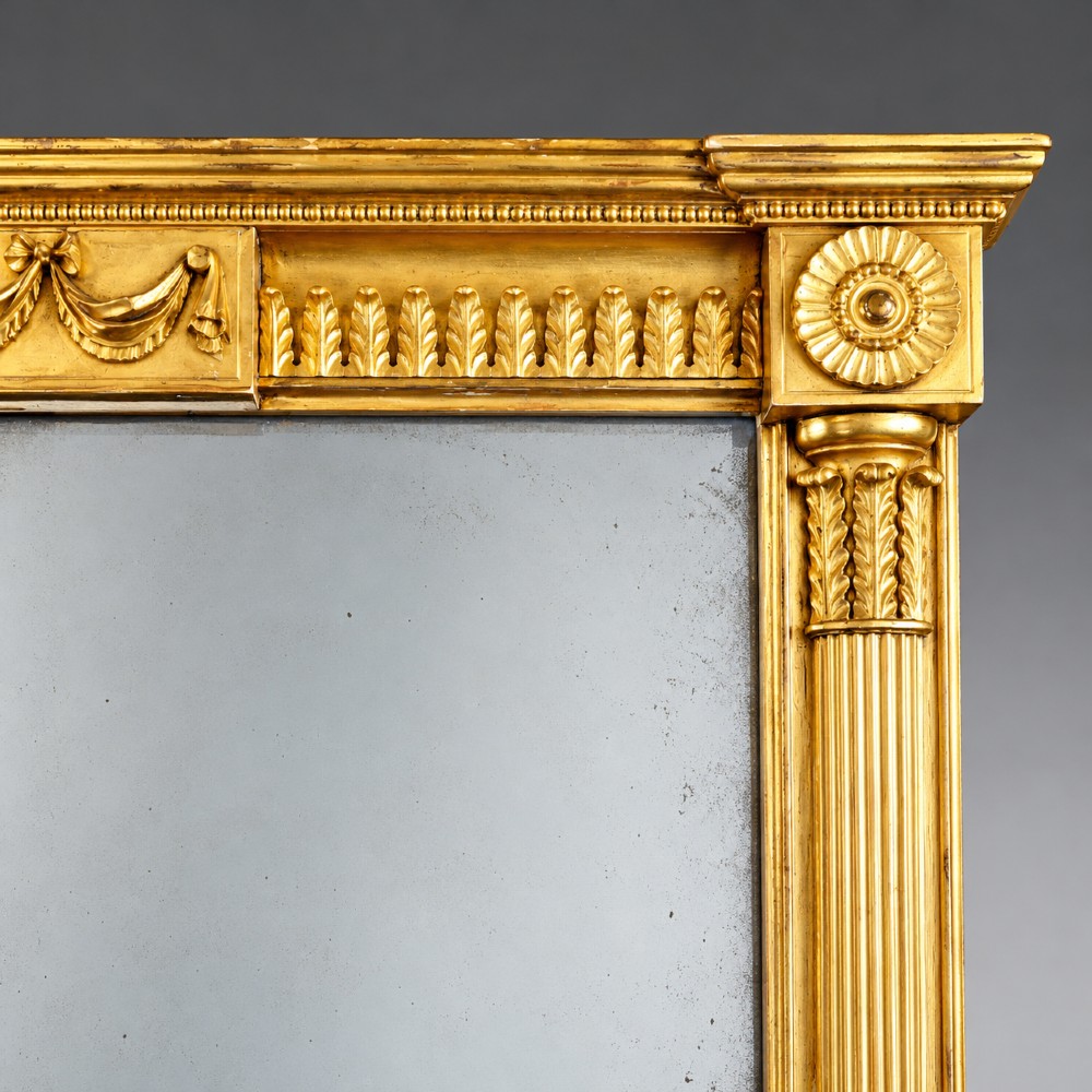 A tall rectangular George III giltwood pier mirror with fluted pilasters, a central drapery swag frieze, and a two-section mirror plate. View IV