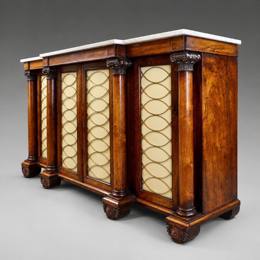 A Regency four-door rosewood side cabinet with a white marble top, carved columns, and brass lattice panels over fabric doors. View III