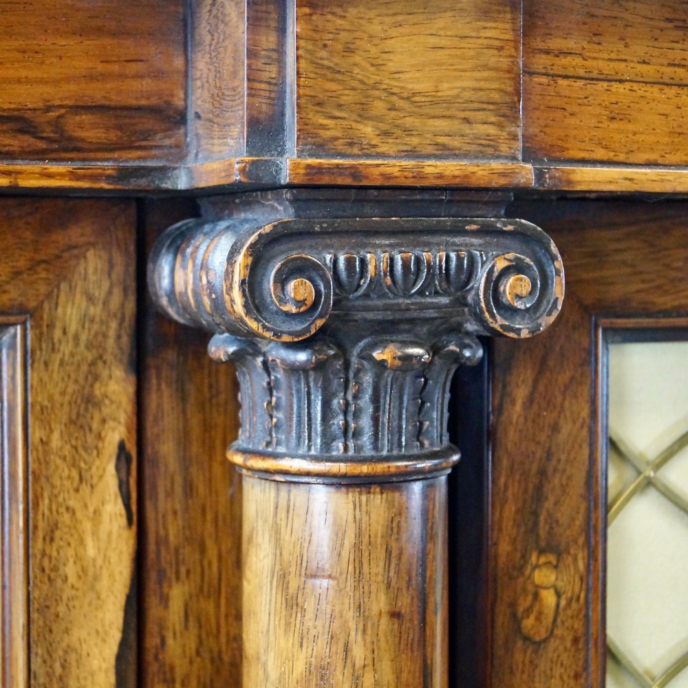 A Regency four-door rosewood side cabinet with a white marble top, carved columns, and brass lattice panels over fabric doors. View IV