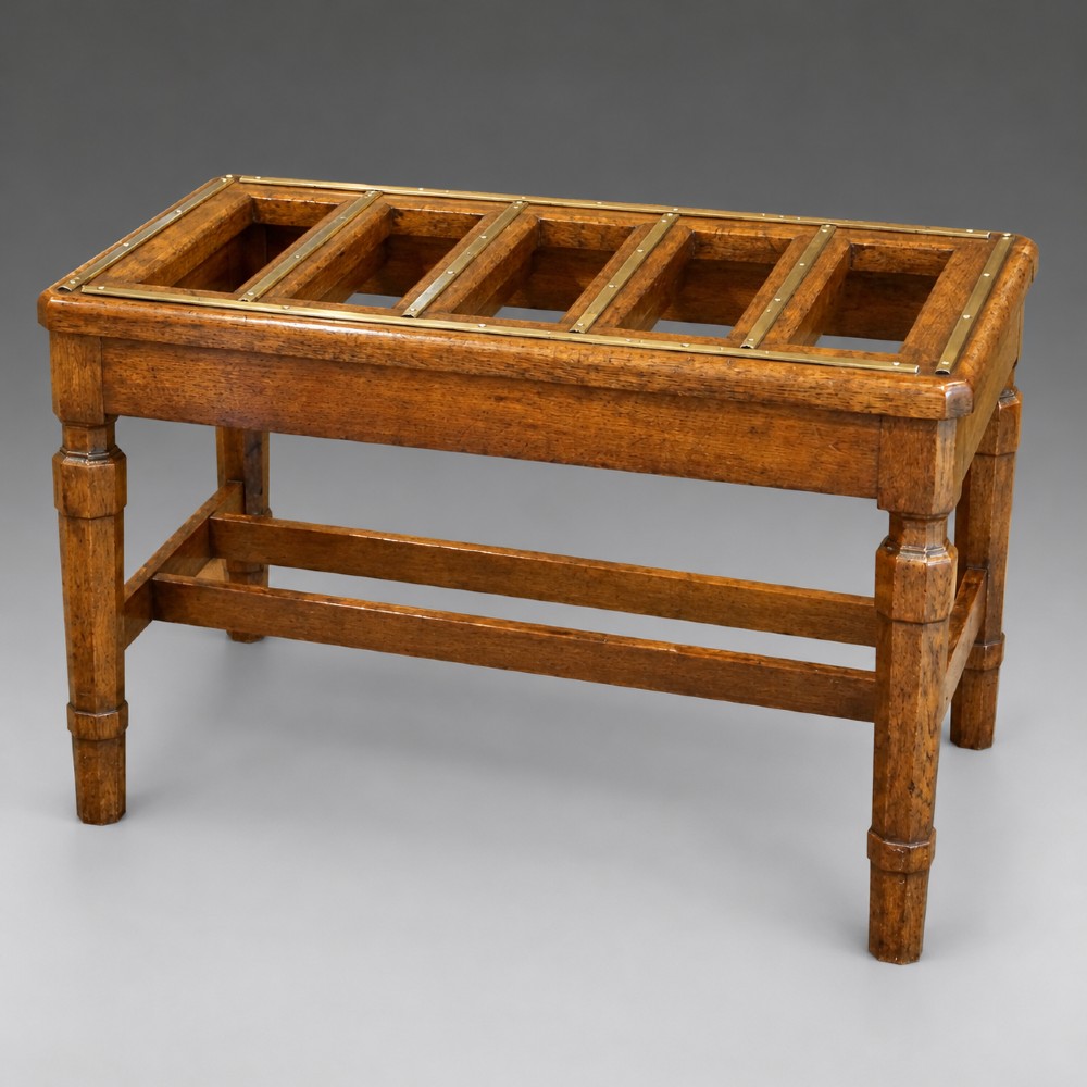 A late nineteenth-century oak luggage stand featuring brass-capped top slats, turned legs, and lower H-stretchers against a grey background. View II