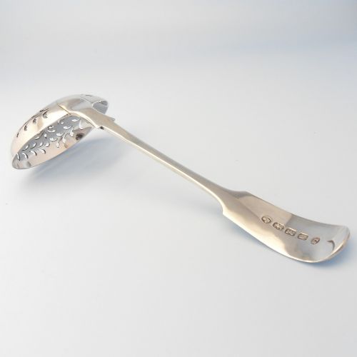 fig 1. A Victorian sterling silver sifter spoon featuring a fiddle-patterned handle with engraved initials and a round pierced bowl with floral lattice cut-outs.