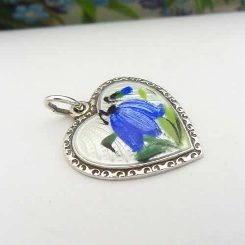 A heart-shaped sterling silver pendant featuring white guilloche enamel with a hand-painted blue bluebell motif surrounded by a beaded border. View III