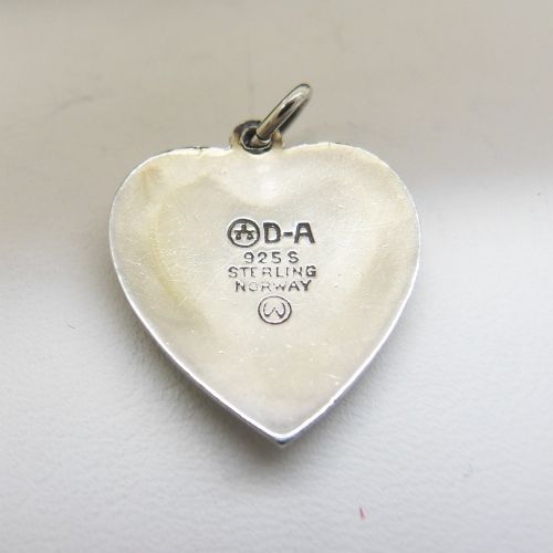 A heart-shaped sterling silver pendant featuring white guilloche enamel with a hand-painted blue bluebell motif surrounded by a beaded border. View V