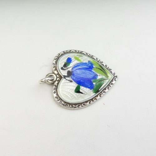 A heart-shaped sterling silver pendant featuring white guilloche enamel with a hand-painted blue bluebell motif surrounded by a beaded border. View VII