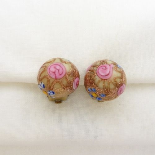 A pair of circular Italian wedding cake glass clip-on earrings featuring cream bases adorned with gold aventurine swirls and applied pink glass roses.